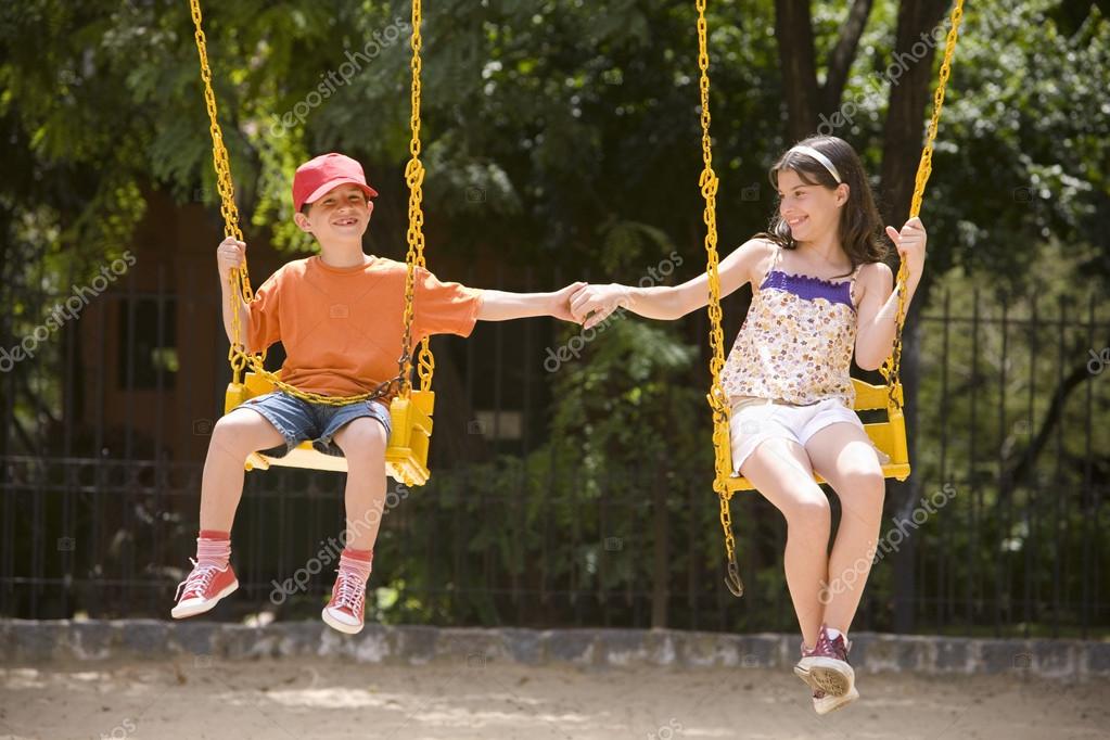 Boy and girl swinging on a rope